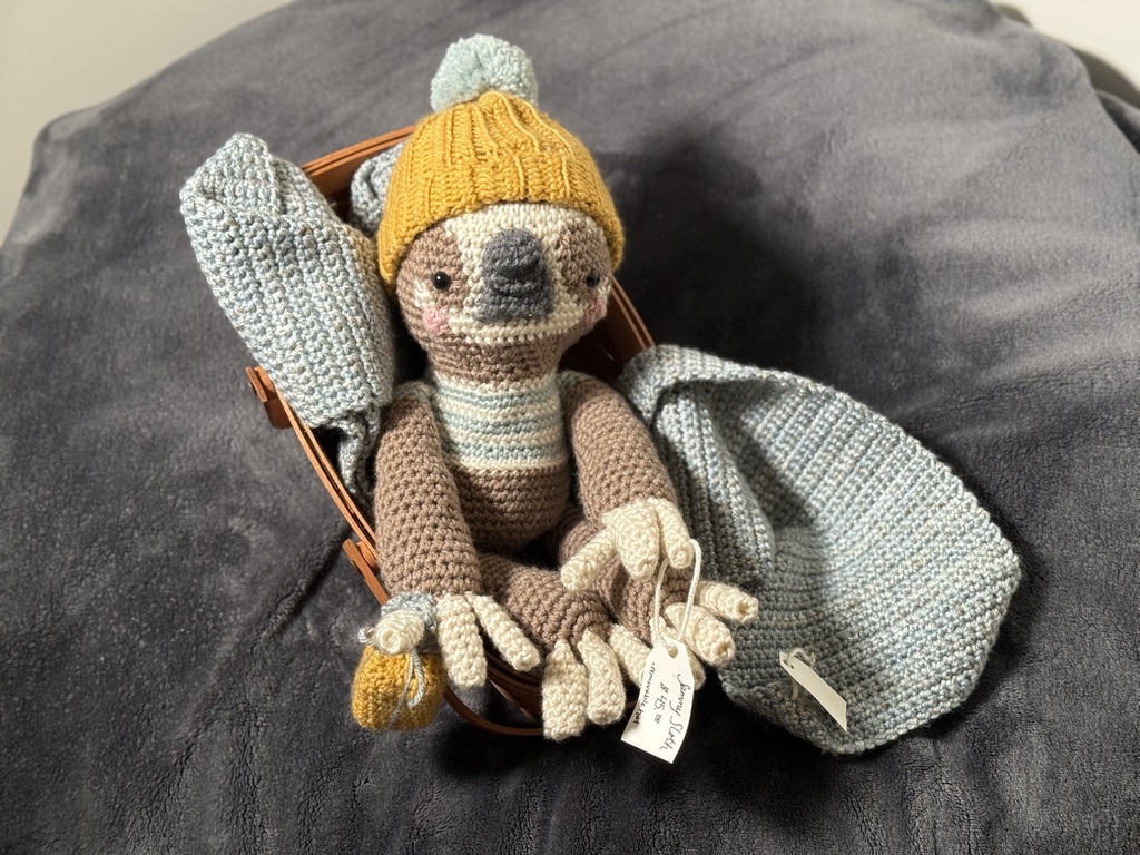 Sunny the Sloth in a mustard bobble hat